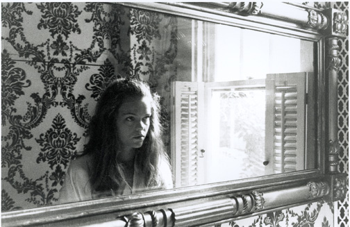 looking at herself in a mirror